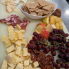 A plate of crackers, cheese and fruit.