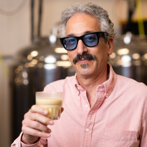Dr. Brett Taubman holds a glass of Rootsii.